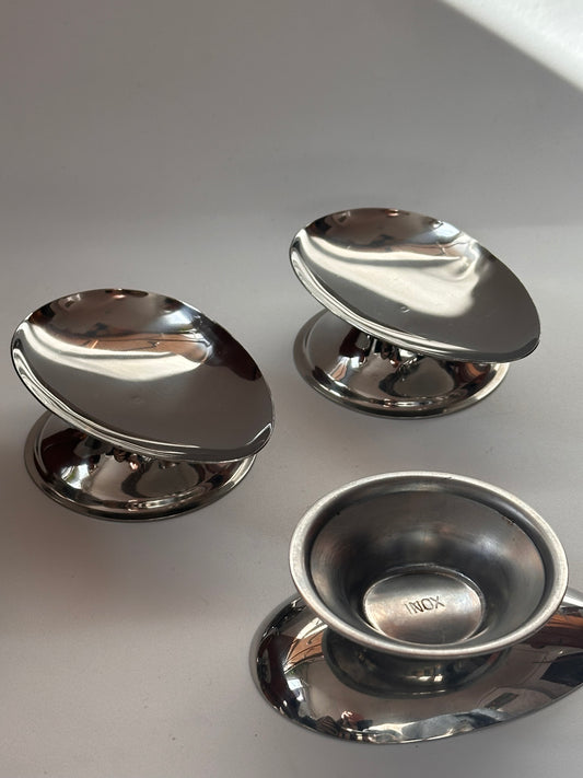 Three minimalistic silver stainless steel dishes with polished finish, designed for serving avocado.