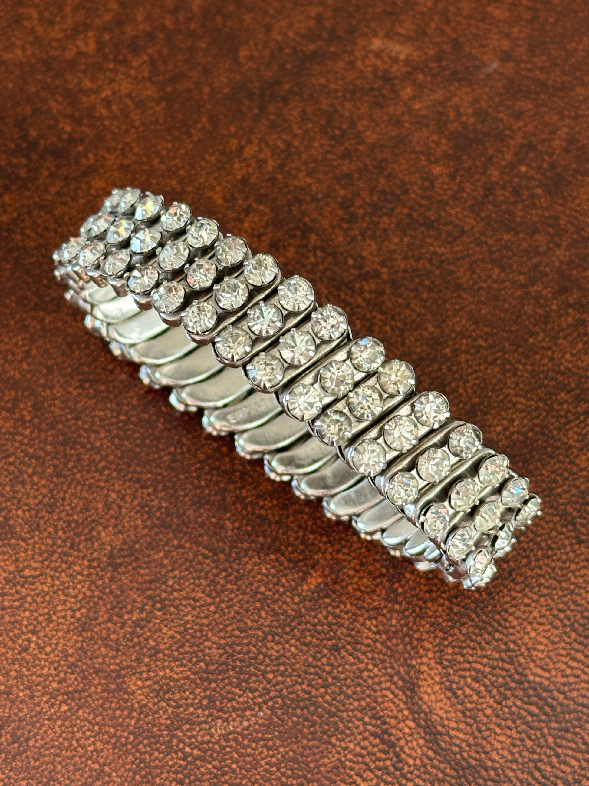 Silver bracelet with clear stones on a brown leather background